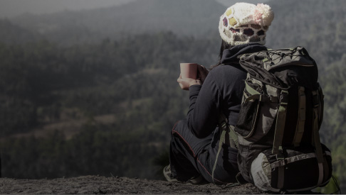 Woman drinking coffee on top of a mountain